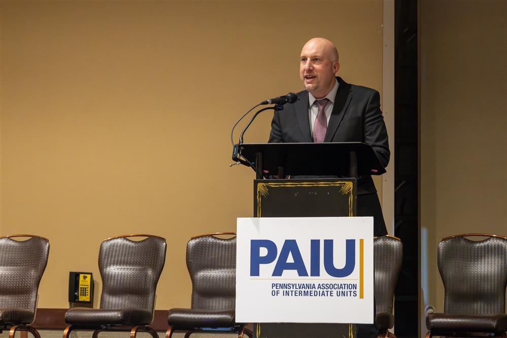  A man speaks to a crowd from a podium.